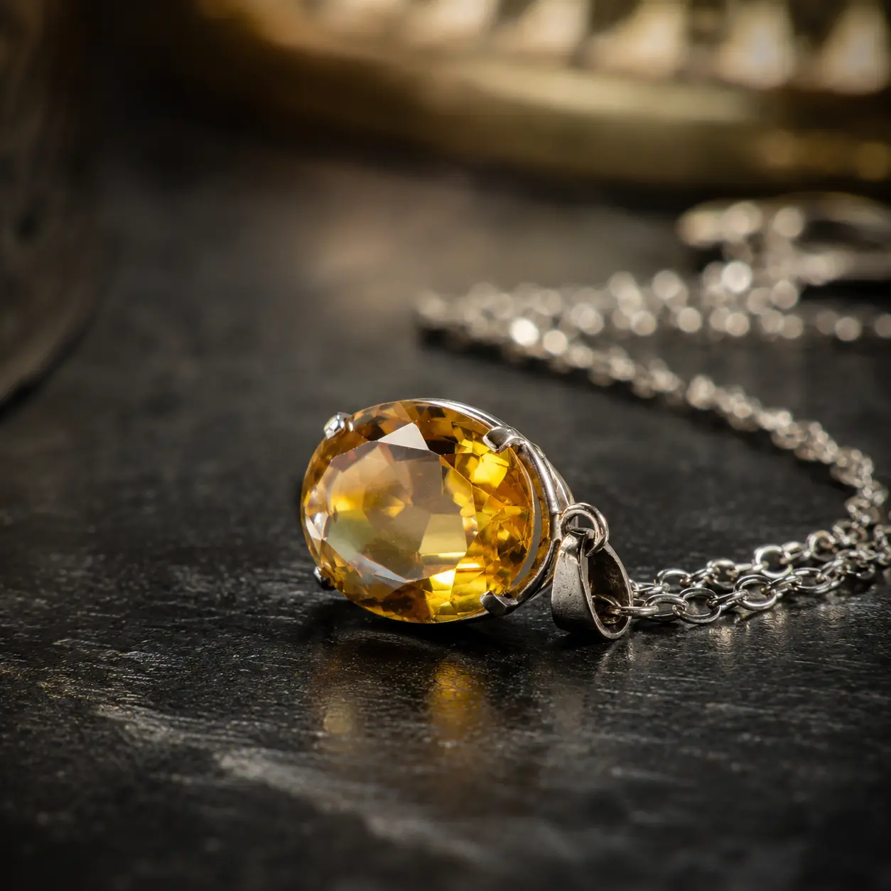 An oval golden citrine pendant in a claw setting on a fine silver chain